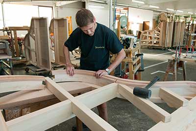man building bosendorfer piano by hand